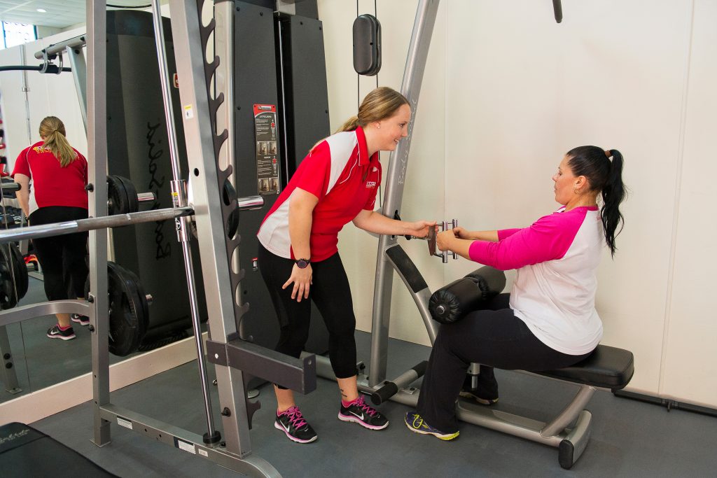 trainer helping client in studio